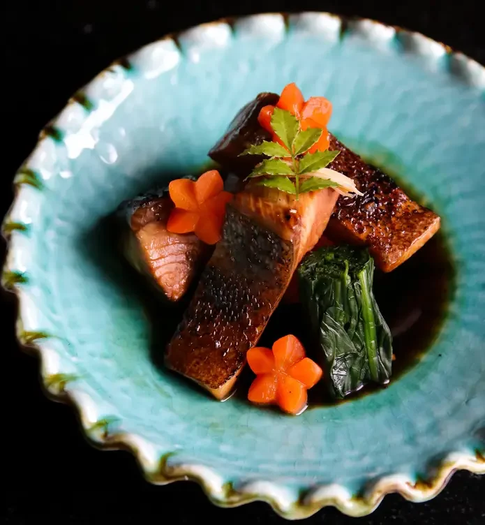 A Pan-Asian dish featuring salmon and flower-shaped carrots at visit Torafuku in Chinatown