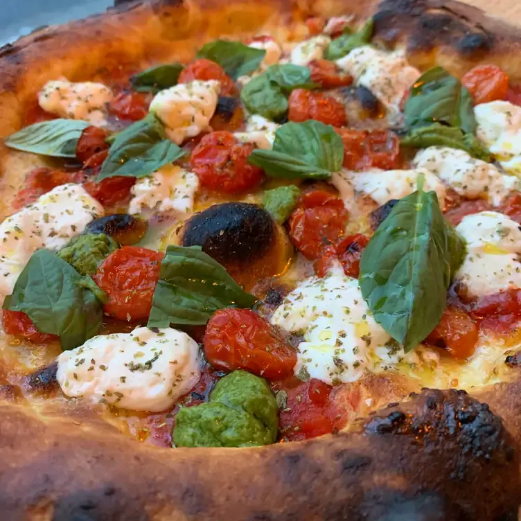 A Neapolitan pizza topped with burrata, tomatoes and basil at Fiorellino Centre-Ville, one of the most romantic restaurants in Montreal for first dates