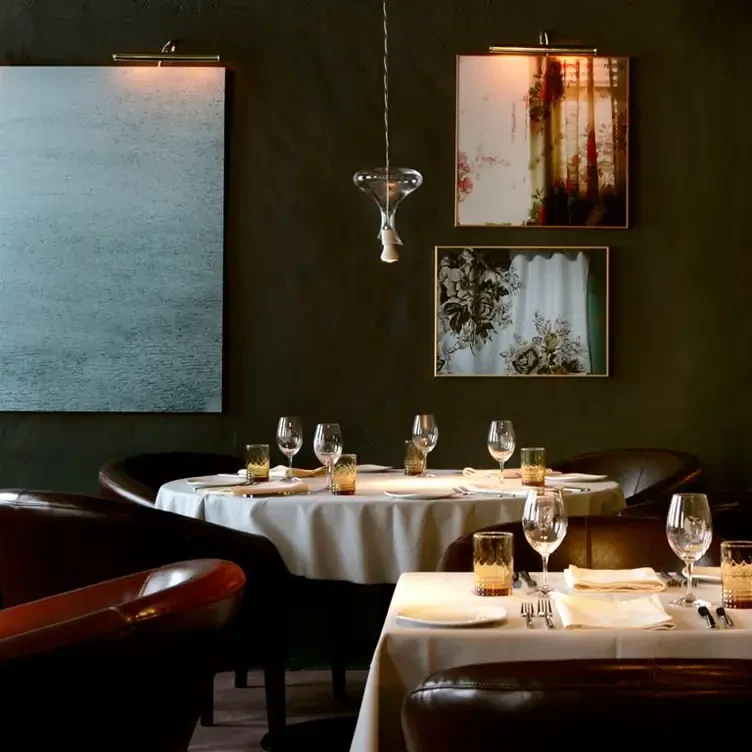 Modern interiors, hanging lights and white tablecloths at Le Club Chasse et Pêche, one of the most romantic restaurants in Montreal for dates