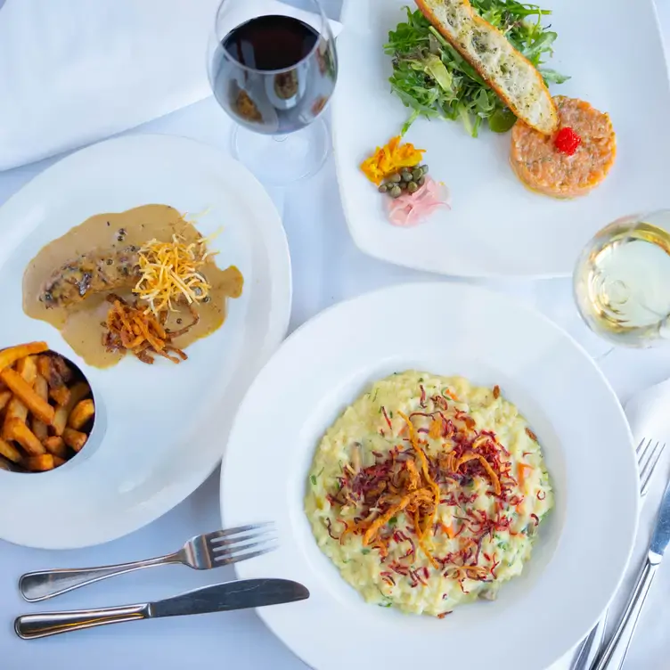 Una table garnie de plats français Chez Lévêque, l'un des meilleurs restaurants romantiques de Montréal