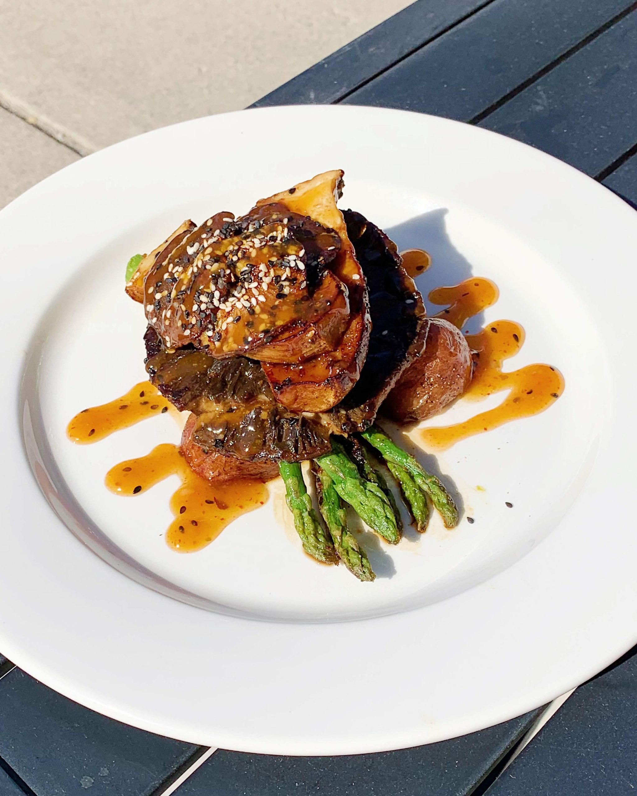 Roasted mushrooms with vegetables and brown sauce on a white plate