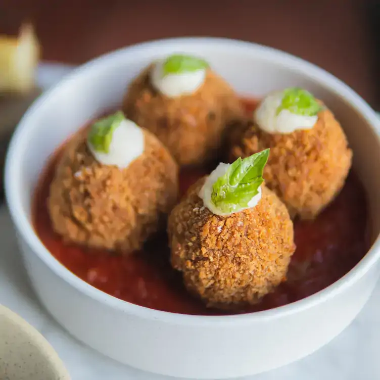 A bowl of four arancini balls at Gia, one of the best Italian restaurants in Toronto