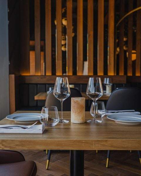 Une table de restaurant avec des verres de vin des assiettes et des couverts