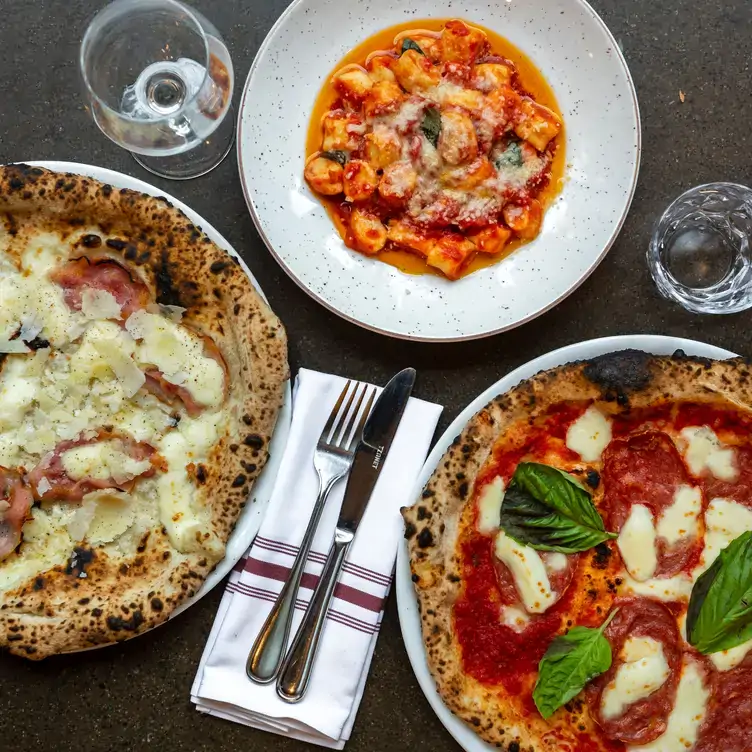 Two pizzas and a bowl of pasta at Fiorellino, one of the best outdoor restaurants in Montreal