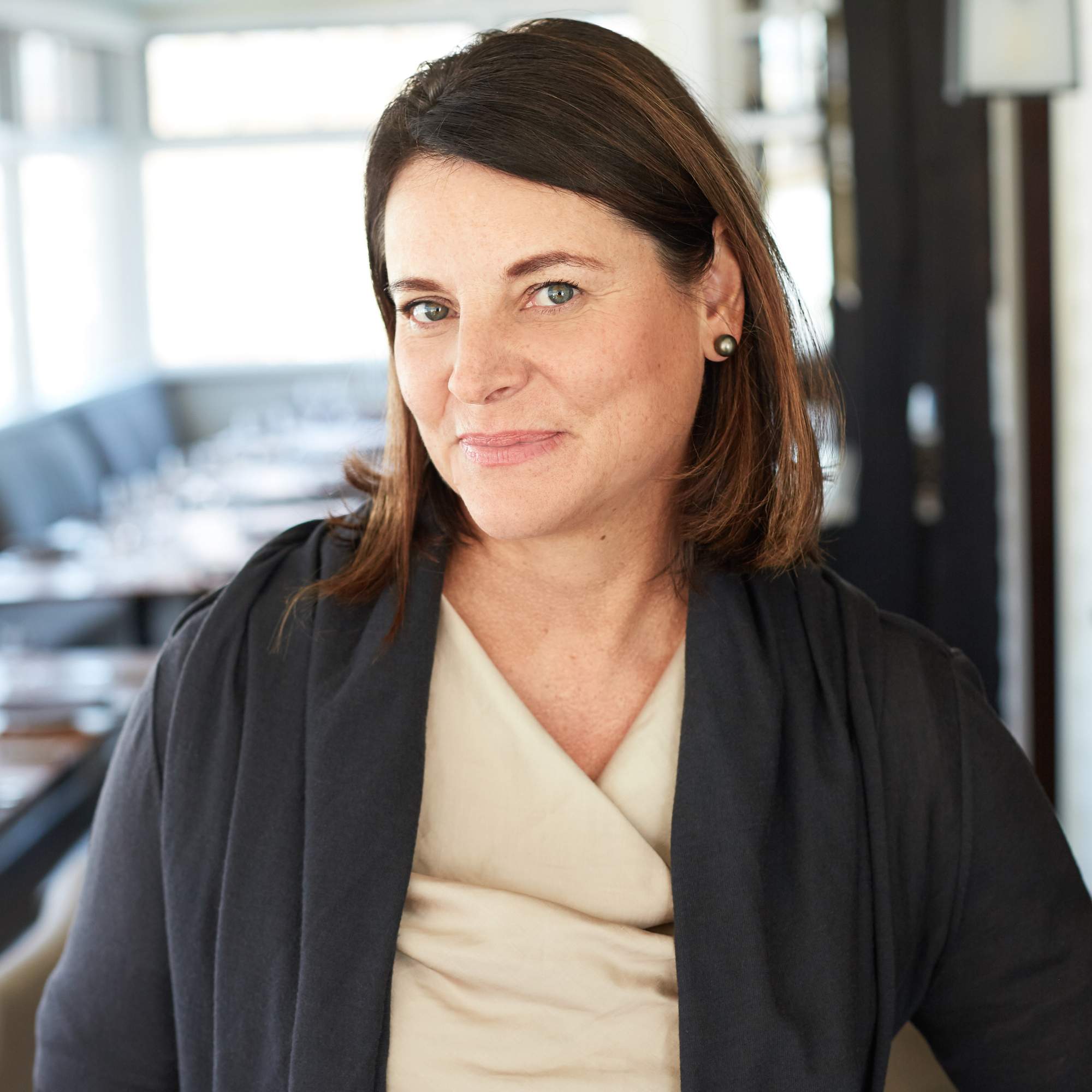 Head shot of Sal Howell, owner of River Café in Calgary, in an off-white dress and a gray cardigan.