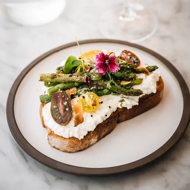 Un toast garni de ricotta, de légumes et de fleurs au LOV McGill, l'un des meilleurs brunchs végétaliens de Montréal.