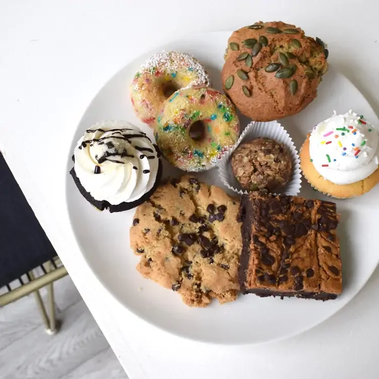 A white plate featuring an array of cookies, doughnuts, muffins and cupcakes at Almond Butterfly Dundas | Bistro