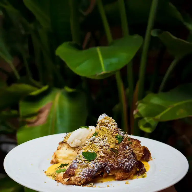 A Lebanese-inspired dish with plants in the background at Bar Reyna, one of Toronto's best restaurants for outdoor dining