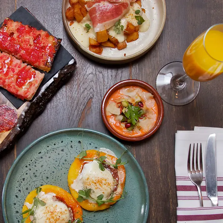 Une table de tapas avec des œufs, du mimosa et du pan con tomate à Ibéricos Taverne à Tapas Espagnoles