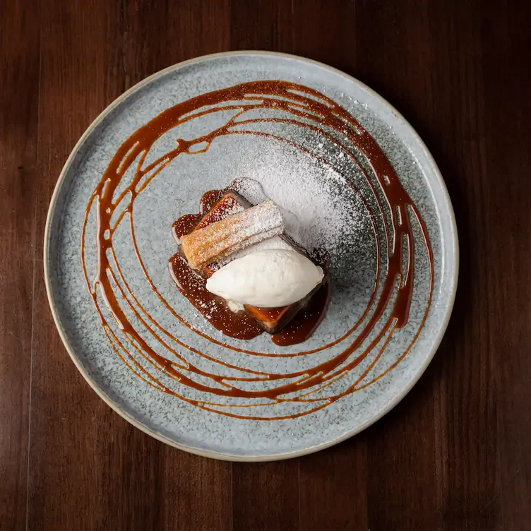 A dessert featuring churros, ice cream and caramel sauce at Ophelia