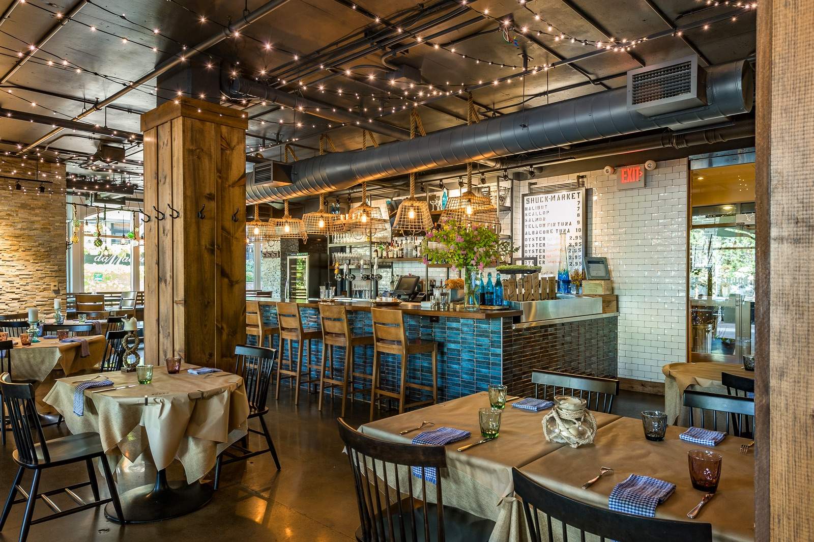 Raw bar under fairy lights at SHUCK Seafood + Raw Bar, one of the best cozy and warm restaurants in Canada