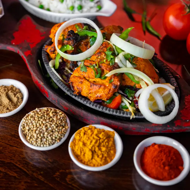 A hot plate with sides is laid out on the table at Ember Indian Kitchen, one of the best Indian restaurants in Vancouver.