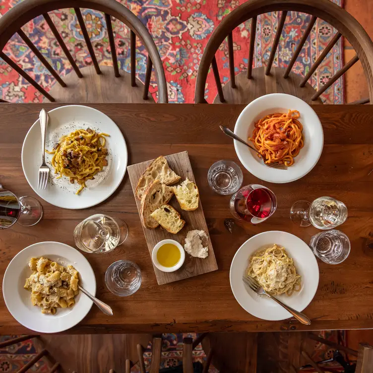 Four pasta dishes around focaccia bread and olive oil at Enoteca Sociale, one of the best Toronto Italian restaurants