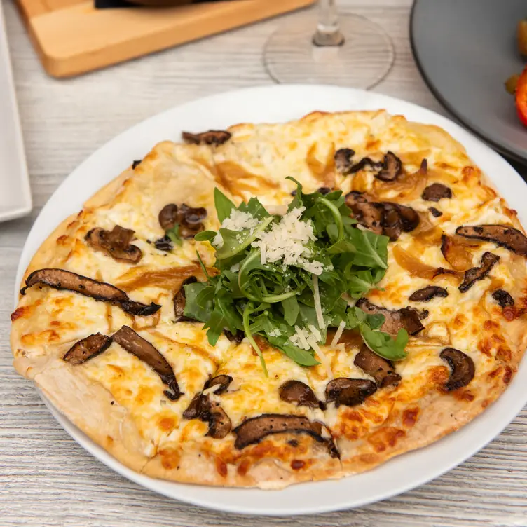 Don’t skip the starters at The Market Bistro. Credit: The Market Bistro Mushroom flatbread with caramelized onions on a plate with arugula at The Market Bistro, in Canmore.