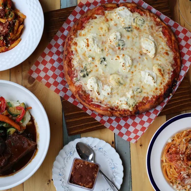 Une pizza aux cinq fromages, ricotta, parmesan, chèvre et fromage bleu, entourée d’assiettes italiennes chez Il Bazzali