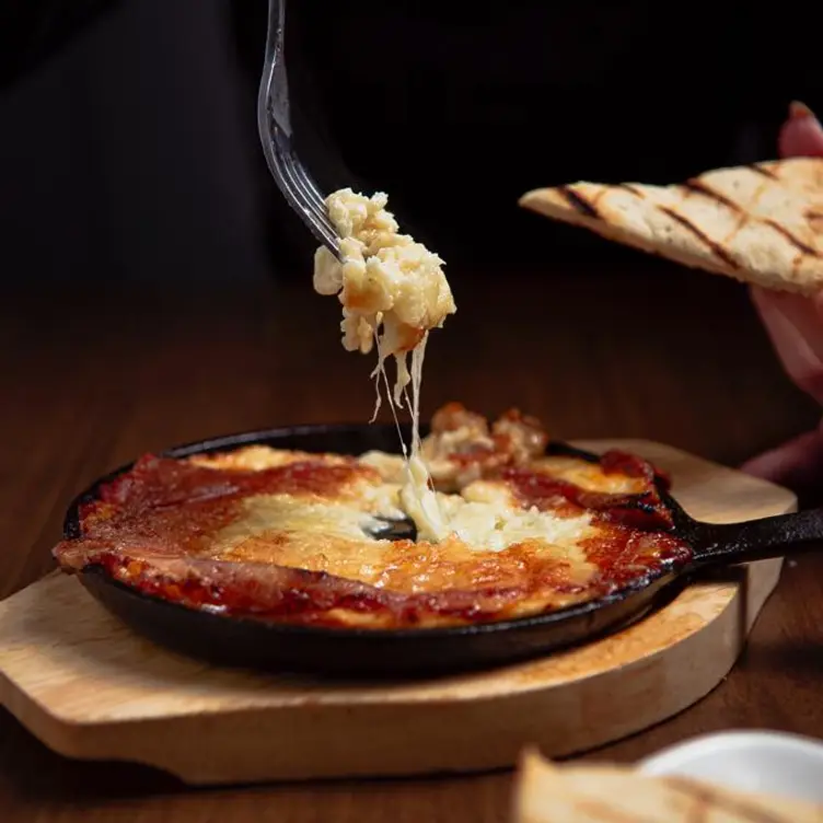 Flamed saganaki cheese with pita at Meza Resto Bar, among the best Greek restaurants in Toronto.