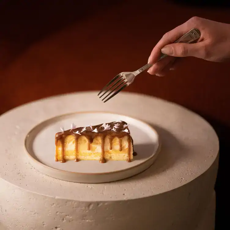 A diner with a fork about to eat a dessert at Fortuna’s Row, one of the best date night restaurants in Calgary.