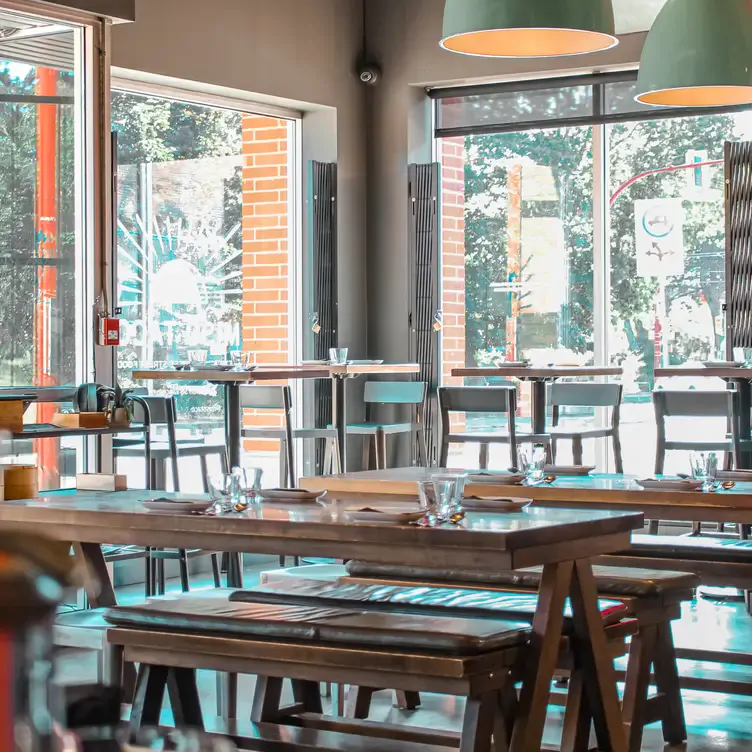 The cozy interior of Miso Taco, with wooden tables and large windows.