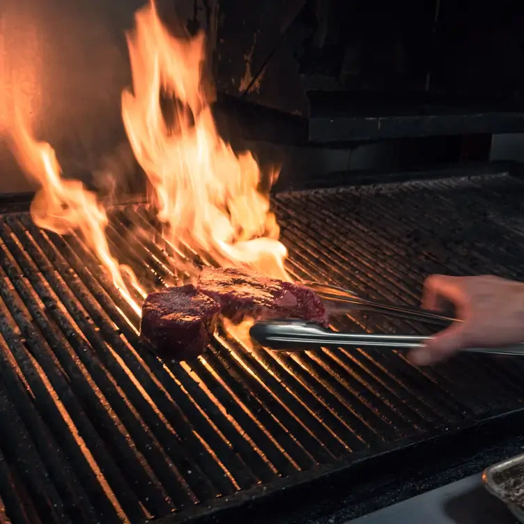 A steak on a flame grill at Vintage Chophouse & Tavern, one of the best romantic restaurants Calgary offers.