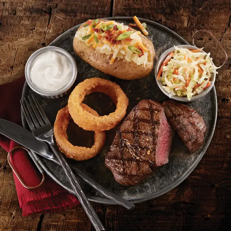 Grilled steak with coleslaw and onion rings at Montana’s BBQ & Bar, one of Calgary’s best family-friendly restaurants.