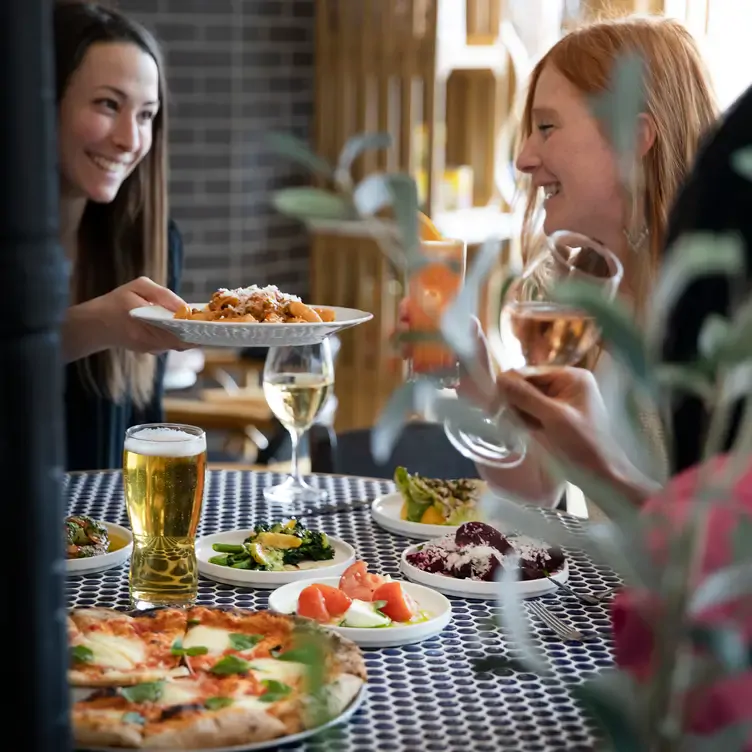 Pasta, pizza, and salad for a shareable meal at LUPO Italian Ristorante & Patio, one of the best family-friendly restaurants near Calgary.