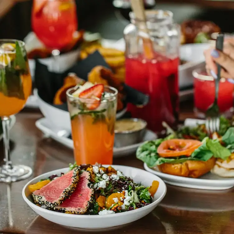 A variety of colourful drinks, a dish with salad and fish at Bin 4 Burger, one of the best family restaurants in Vancouver.