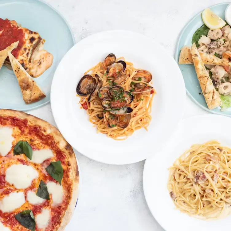 Homemade pizzas, pasta with clams, or pasta carbonara fill one of Marcello's tables.