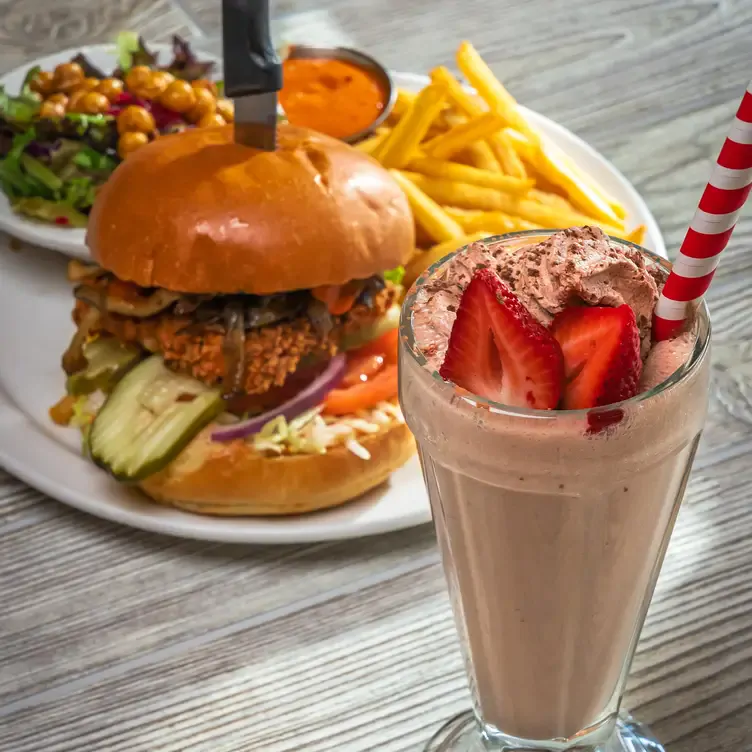 A plate with a burger, and fries, and a towering chocolate sundae at Chickpea, one of the best family restaurants in Vancouver.