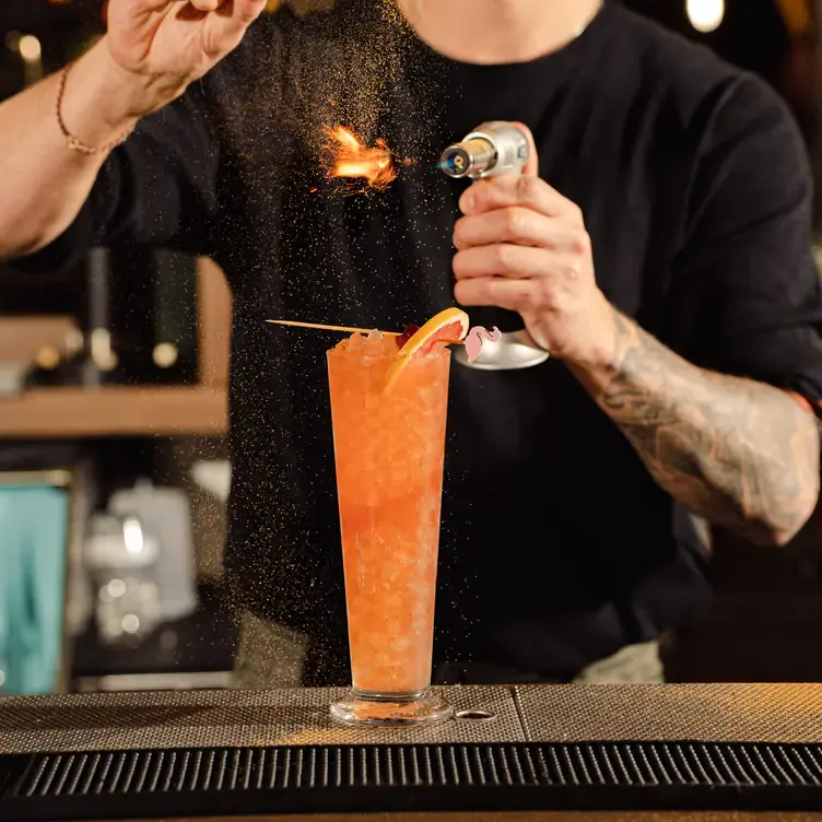 A bright orange cocktail topped with grapefruit at the Flamingo Room, one of the best new restaurants Vancouver has to offer.