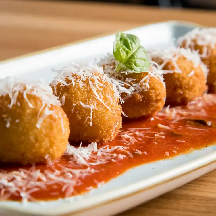 Parmesan basil tops breaded meatballs at Rebel Food and Drink, one of the best Edmonton brunch places.