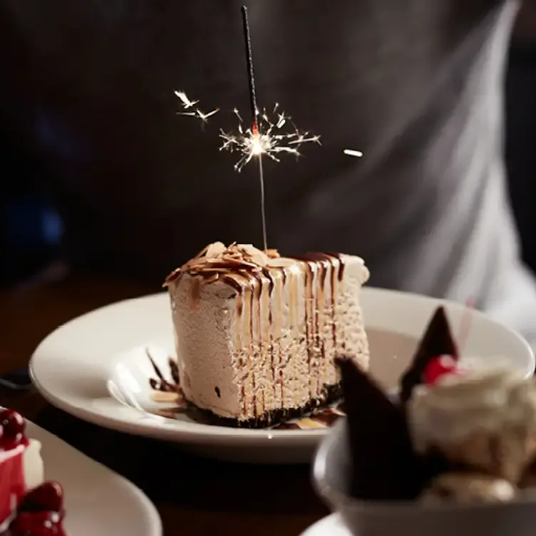 Un gâteau au chocolat sur lequel on verse une sauce au chocolat chez The Keg Steakhouse + Bar, l’un des meilleurs restaurants familiaux de Montréal.