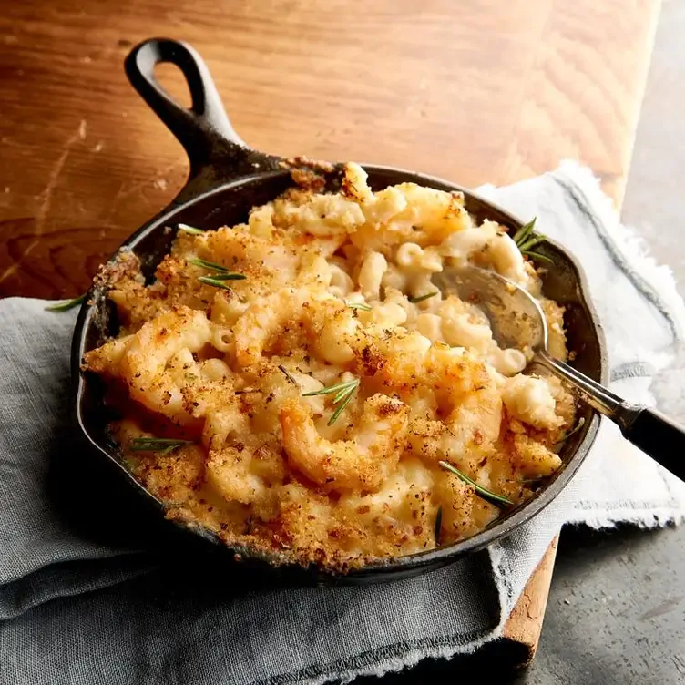 A small skillet with breaded shrimp atop mac and cheese from Bubba Gump, one of the best family restaurants in Edmonton.