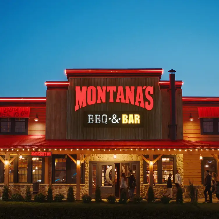 The illuminated facade at night of Montana's BBQ & Bar, one of the best family restaurants in Edmonton.