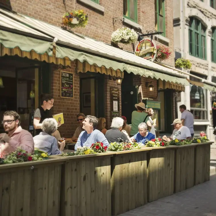 Une terrasse ensoleillée avec de nombreux clients chez Crêperie Chez Suzette Inc, l’un des meilleurs restaurants familiaux de Montréal