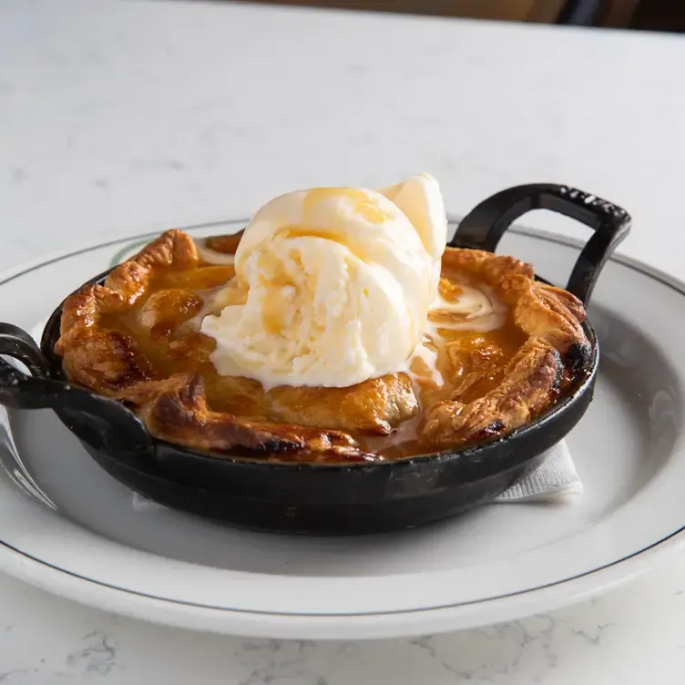 A dessert pie in a small skillet with a scoop of ice cream on top from Hart’s Table & Bar, one of the best family restaurants in Edmonton.