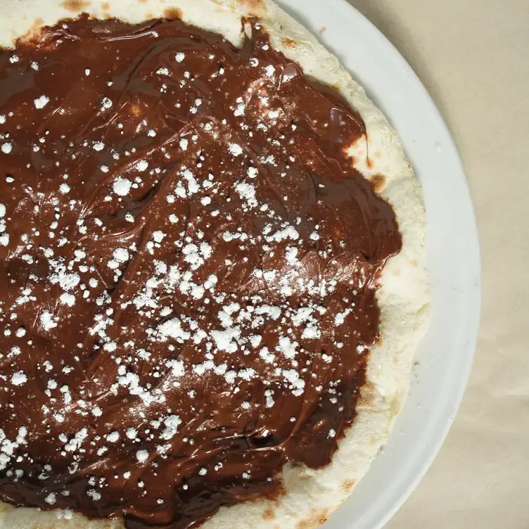 Une pizza au chocolat saupoudrée de sucre glace chez BEVO Bar + Pizzeria, l’un des meilleurs restaurants familiaux de Montréal.