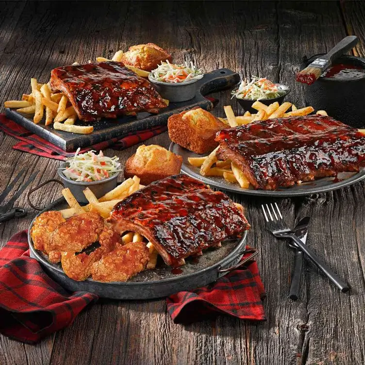 Three plates with pork back ribs of different sizes, fries, coleslaw, and a dinner roll from Montana's BBQ & Bar, one of the best family restaurants in Edmonton.