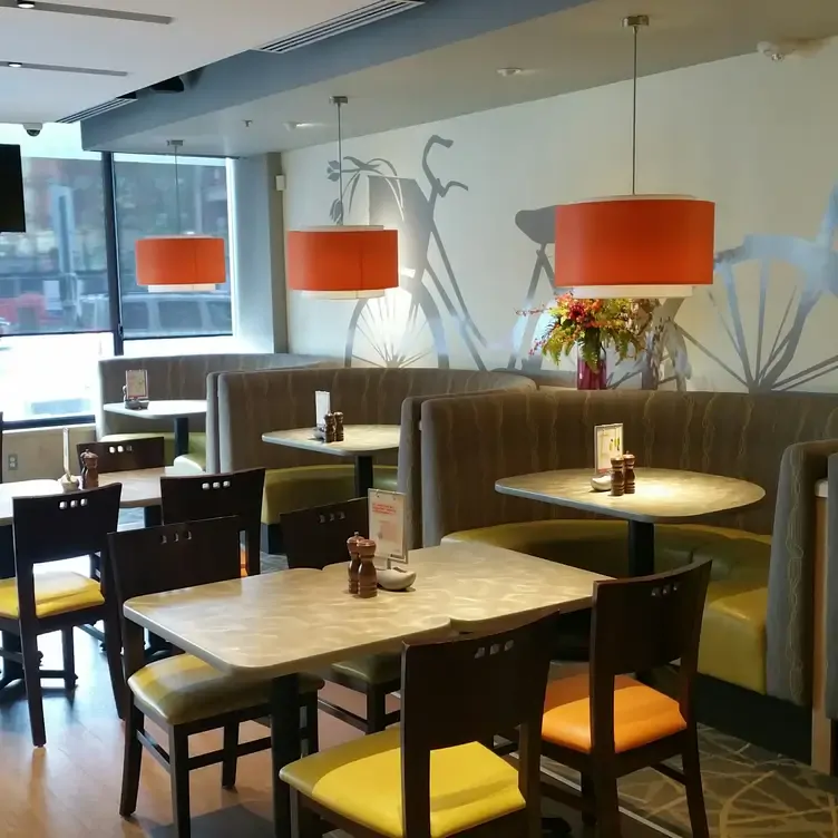 A restaurant room with various tables and booths bathed in warm light at De Dutch, one of the best family restaurants in Edmonton.