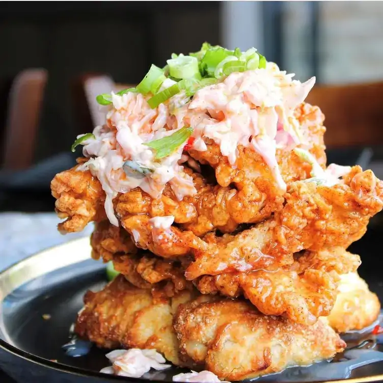 A stack of Korean-style fried chicken decorated with coleslaw from Lexington Smokehouse & Bar, one of the best brunch spots in Ottawa.