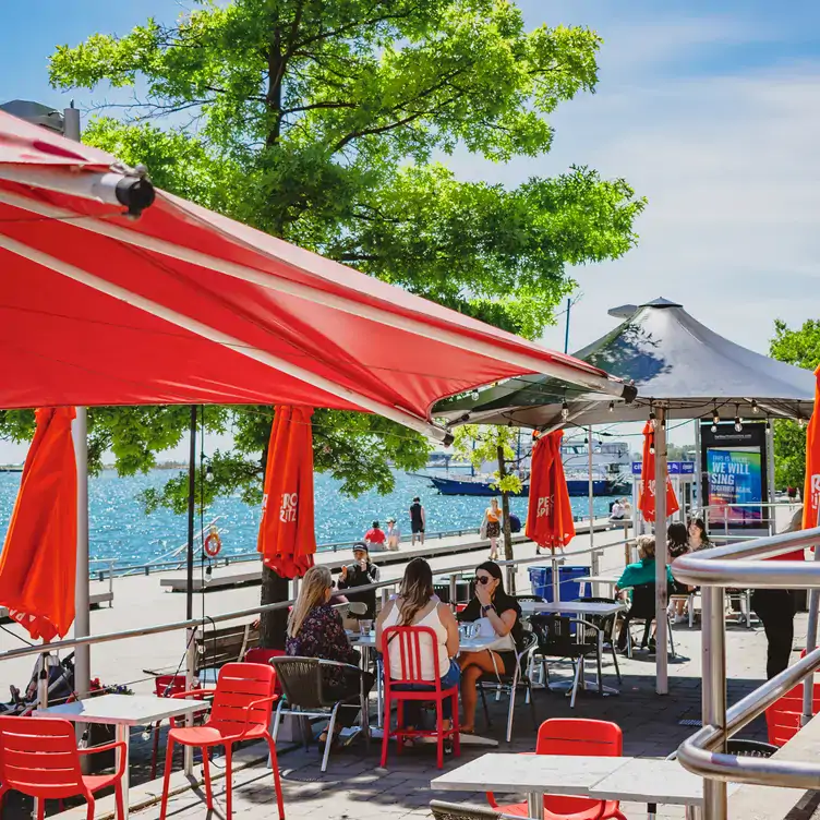 A sunny patio and lake view at Pie Bar Pizzeria, one of the best restaurants in Harbourfront Toronto.