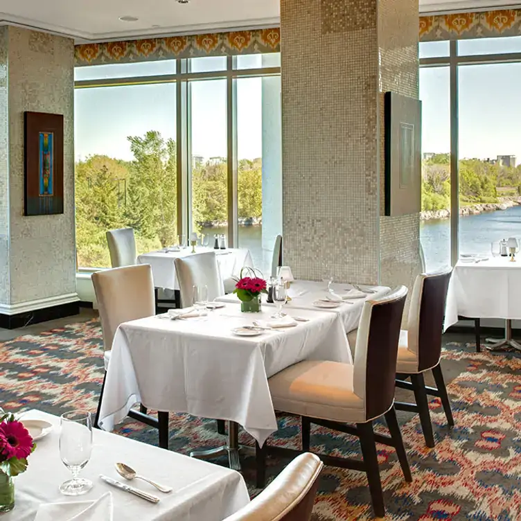 An indoor area with a large window overlooking the Ottawa River at Arôme - Casino du Lac Leamy, one of the best restaurants with a view in Ottawa.