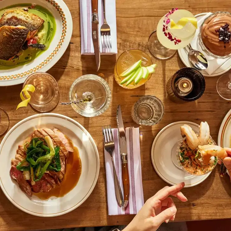 A table with meat, mousse, and cocktails at The Rosebud, one of the best restaurants in Harbourfront Toronto.