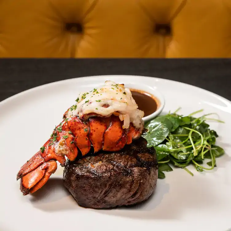 A plate with a piece of red meat topped with a lobster at Caffè Italiano, one of the best restaurants with a view in Ottawa.