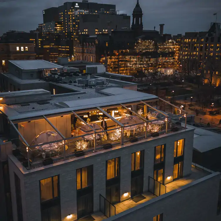 An elevated view of a terrace with tables in heated bubbles at Terrasse William Gray, one of Montreal's best rooftop restaurants.