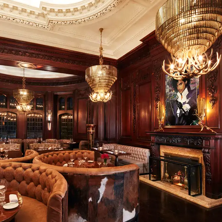 The elegant dining room with booth seating and gold art-deco chandeliers.