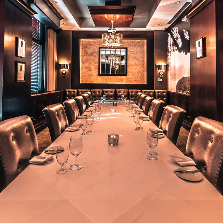 The private dining room at Vintage Chophouse & Tavern, with a long table set for 12 and leather furnishings.