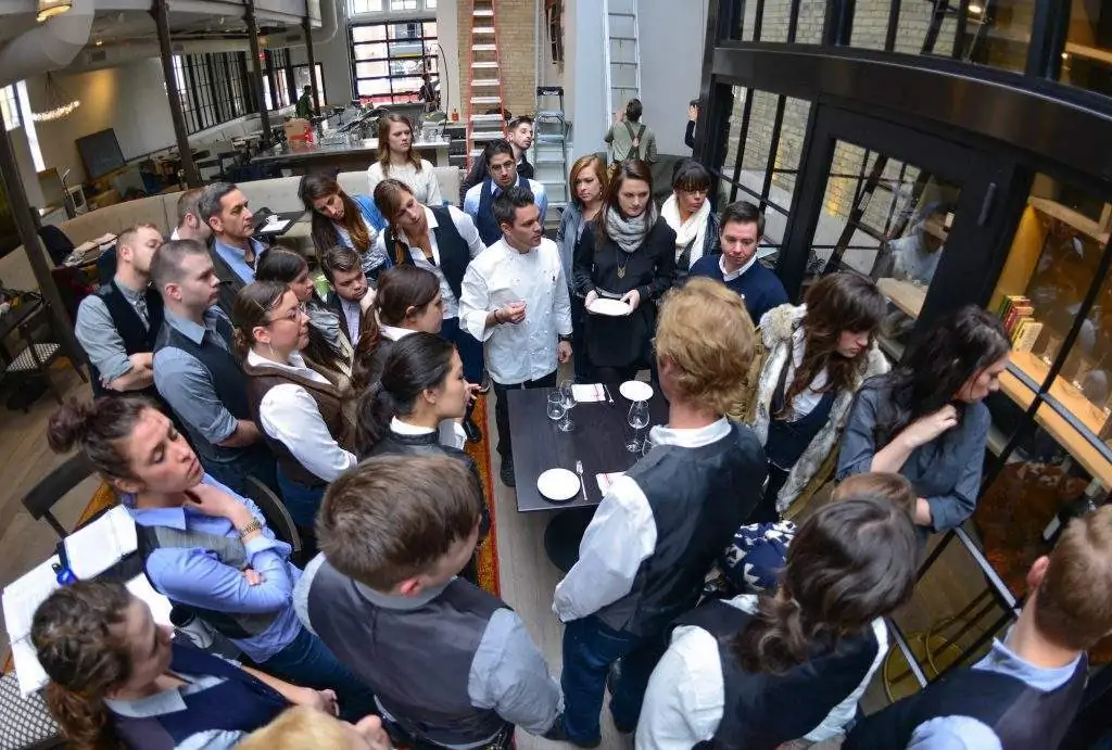 Restaurant staff having a group training session before the restaurant opening