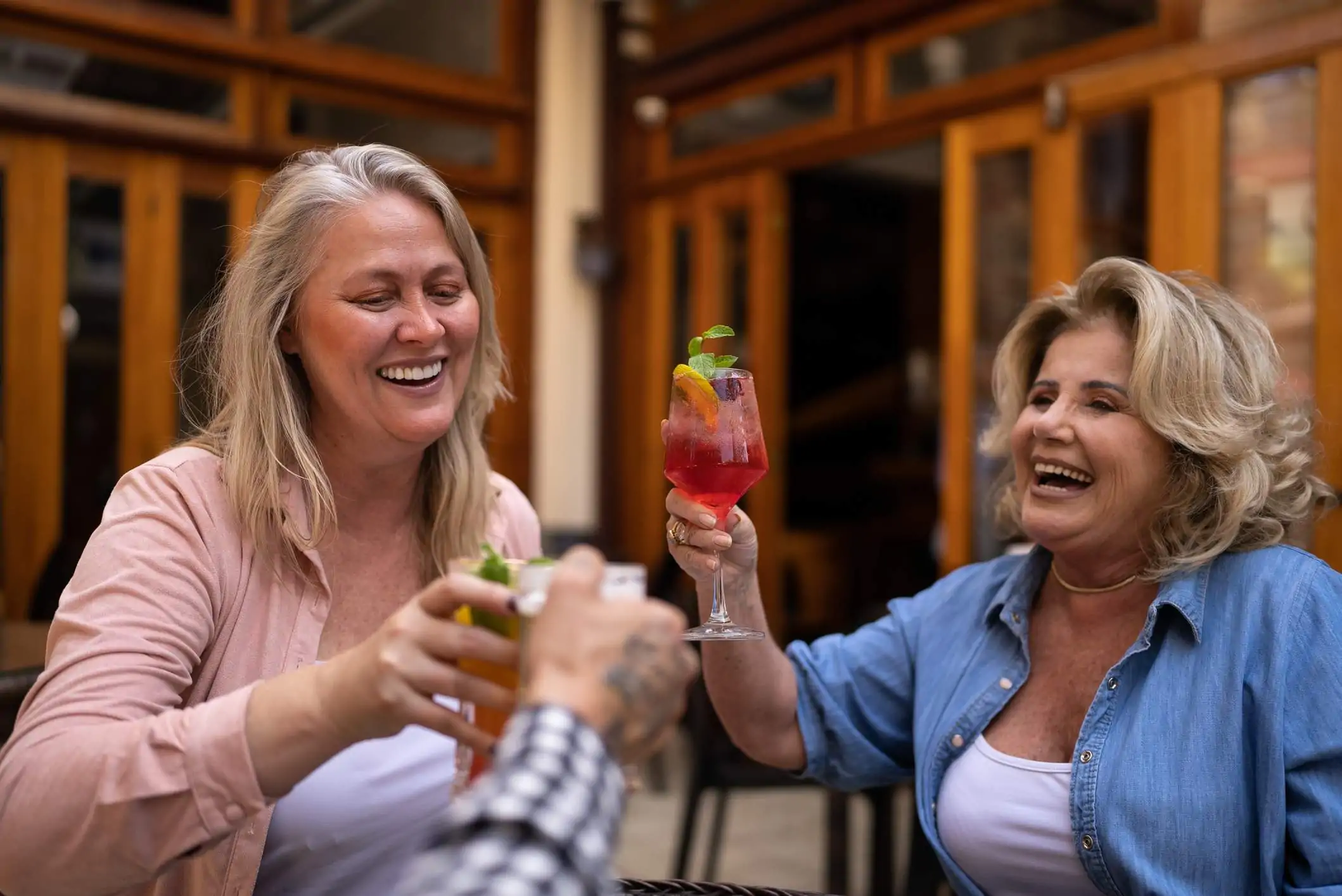 Image depicts three people cheersing non-alcoholic beverages.