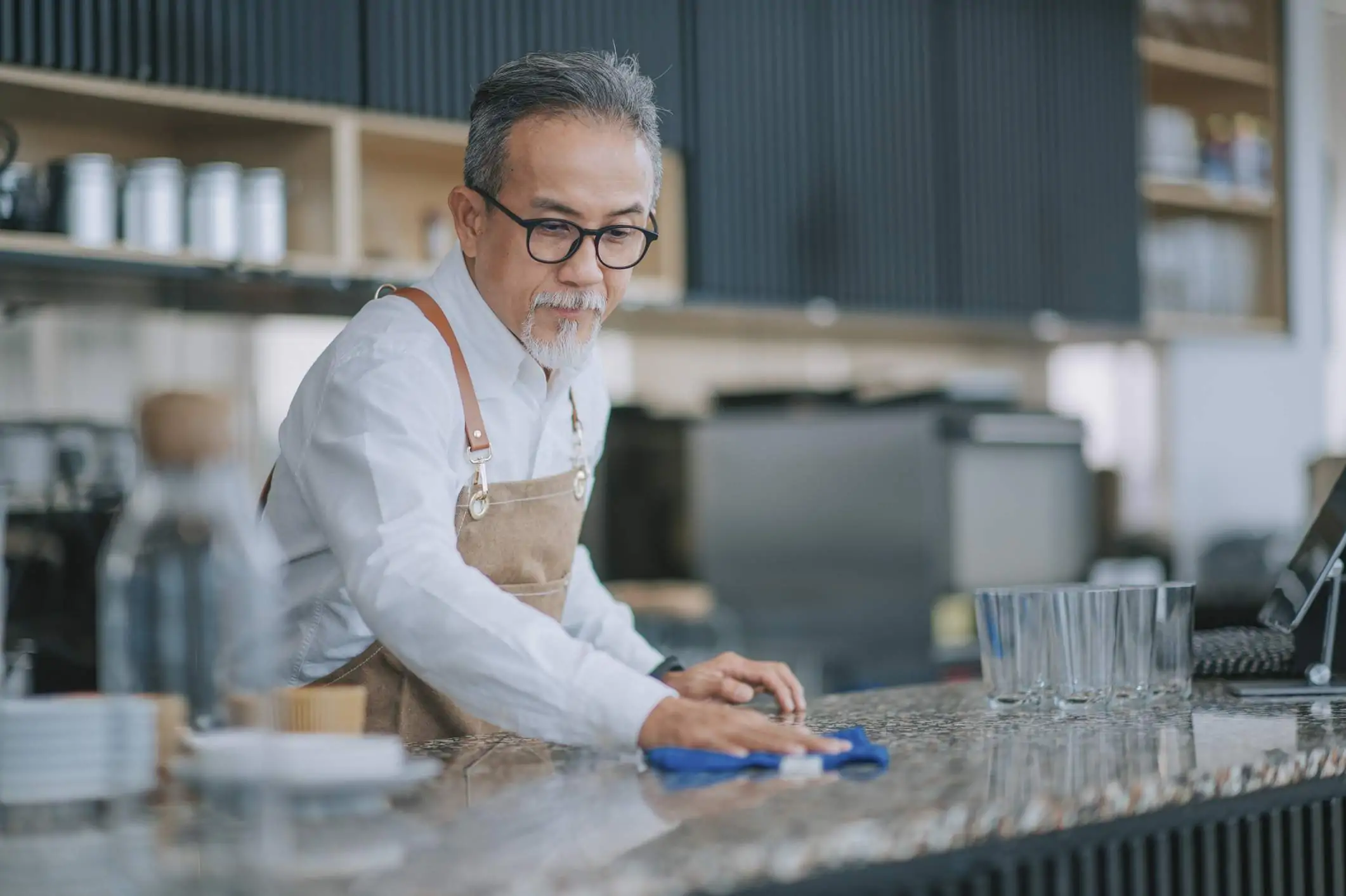 Image depicts a restaurant worker cleaning a counter.